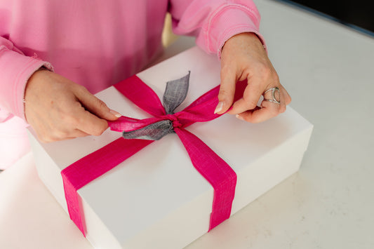 Female founder packing thoughtful client gift for business